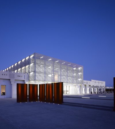 Exterior view at nighttime showing Mathaf's contemporary building brightly lit