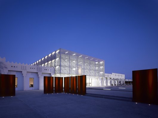 Exterior view at nighttime showing Mathaf's contemporary building brightly lit