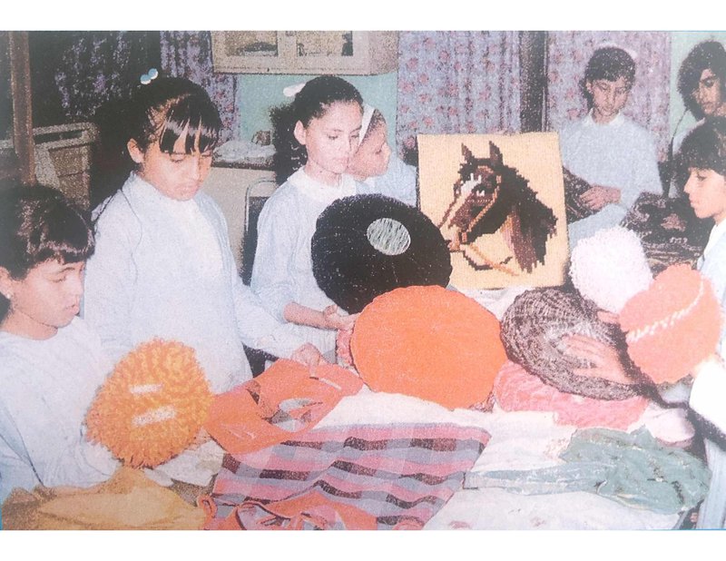 صورة قديمة لطالبات في صف الحياكة يرتدين الزي المدرسي.
