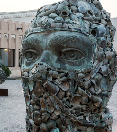 A close shot of two of the three sculptures showing heads wearing military gear, with one wearing a face cover and the other a gas mask