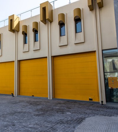 Landscape view of the exterior of the Fire Station's Garage Gallery's bright yellow door shutters