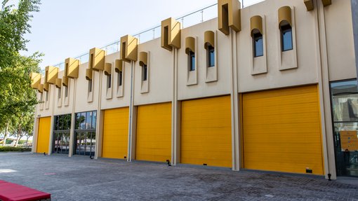 Landscape view of the exterior of the Fire Station's Garage Gallery's bright yellow door shutters
