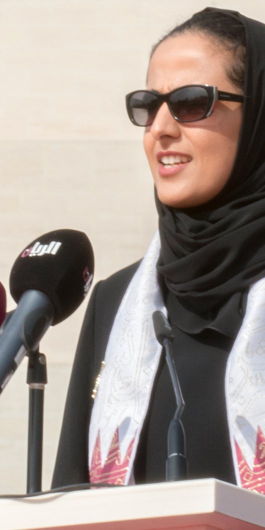 Her Excellency Shaikha Al Mayassa stands at a podium speaking