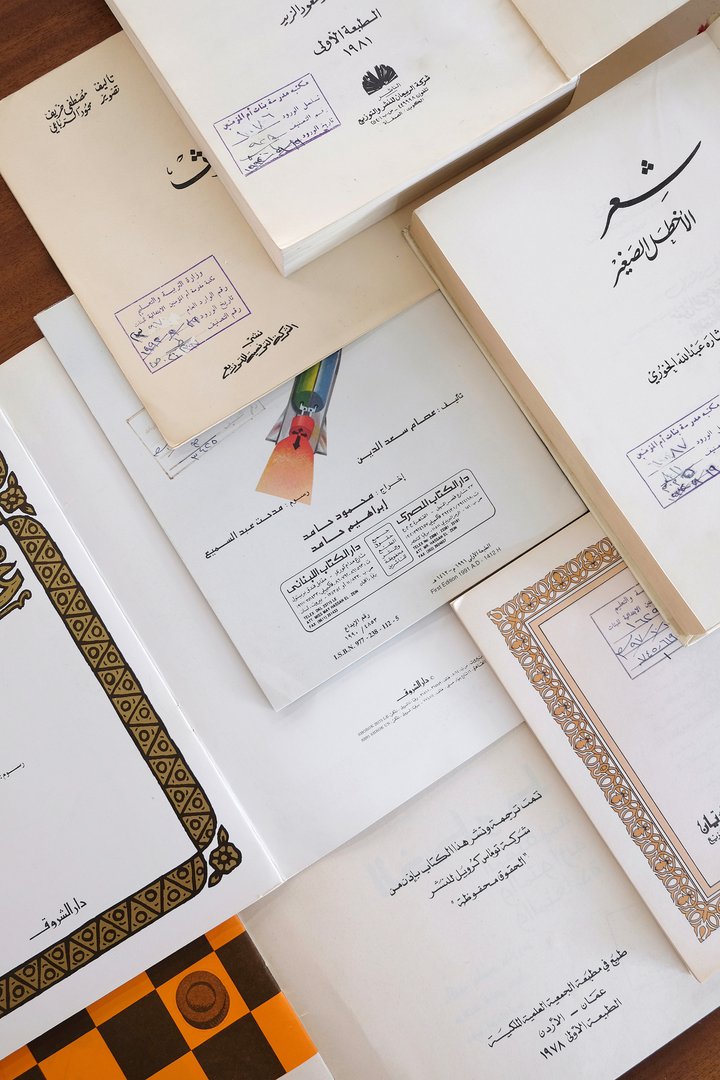 مجموعة مختارة من كتب الأطفال المدرسية العربية العتيقة معروضة لإظهار الأغلفة الداخلية.