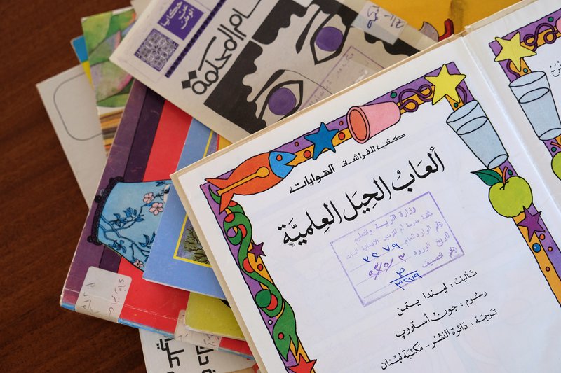 A pile of colourful vintage Arabic school books in Liwan's library.
