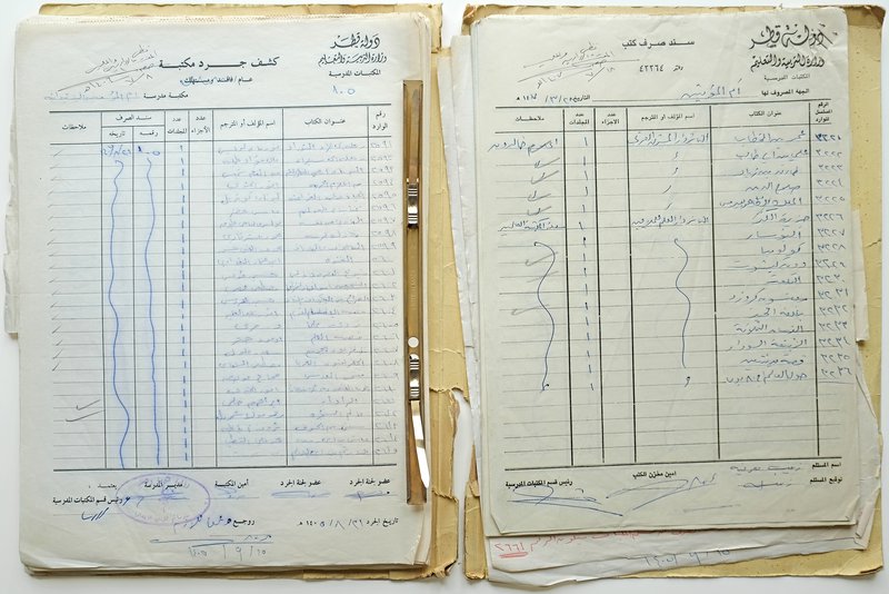 سجل ورقي قديم للمدرسة مكتوب باللغة العربية ومصوّر من الأعلى.