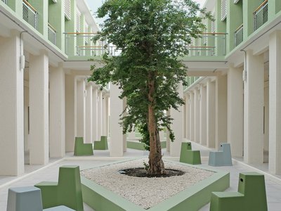 Exterior view of a courtyard with a tree and modern seating.