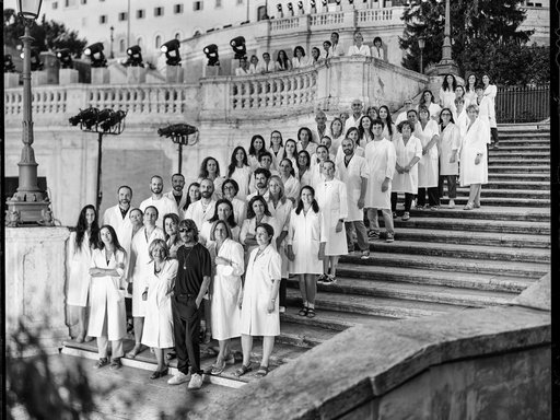 A group of people in white coats standing on the Spanish Steps in Rome.