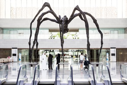 A wide-angle shot showing the full view of the spiders uniquely sculpted bronze and stainless steel legs