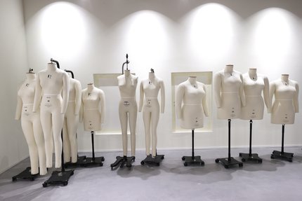 A row of unclothed white coloured mannequins of differing sizes and shapes