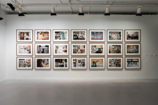A wall with multiple framed photos in landscape.