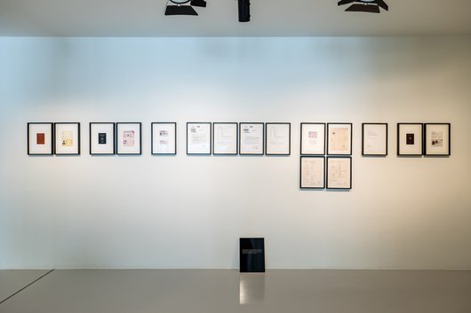 A wall with multiple hanging frames.