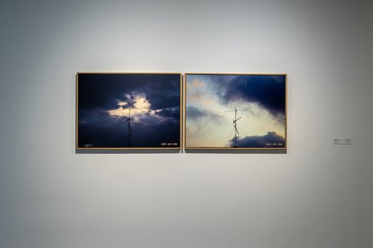 Two framed photos of a television antenna against a cloudy sky.