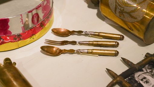 Gold-hued utensils lay between other similarly coloured items on display.