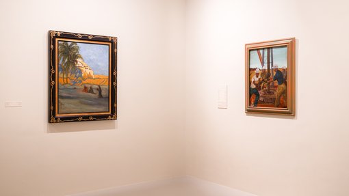 Two framed artworks shown displayed in a corner of a white gallery space.