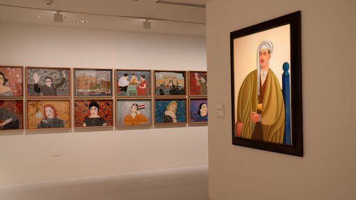 Corner gallery view, with multiple portrait paintings across one wall and another larger, framed portrait painting on the left.