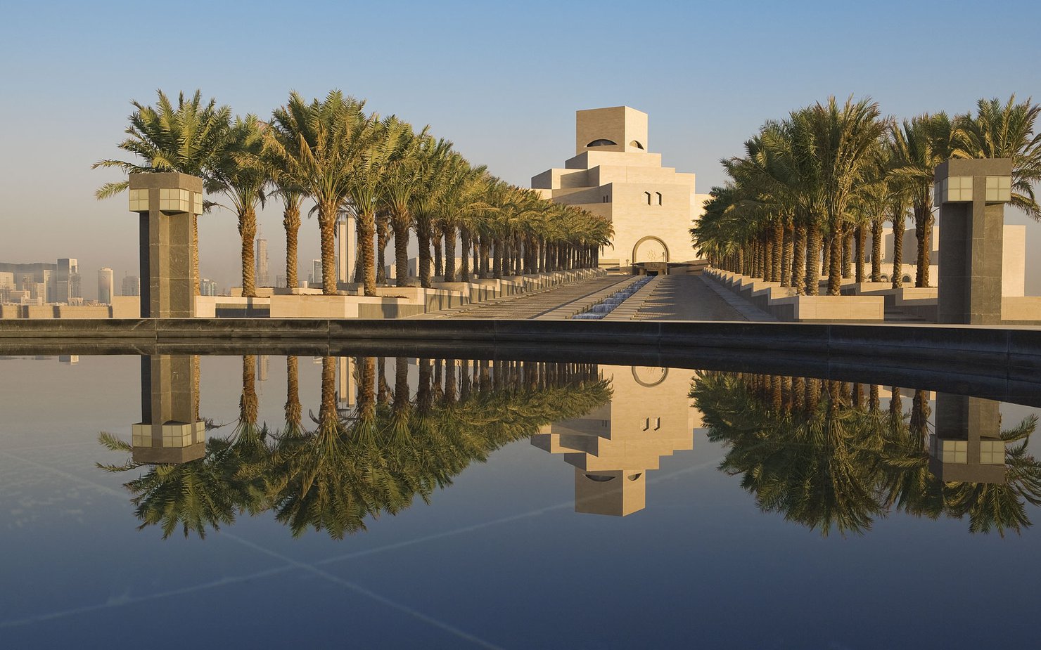 Asymmetrical view of the MIA with stairs, palm trees and water fountain leading up to the entrance