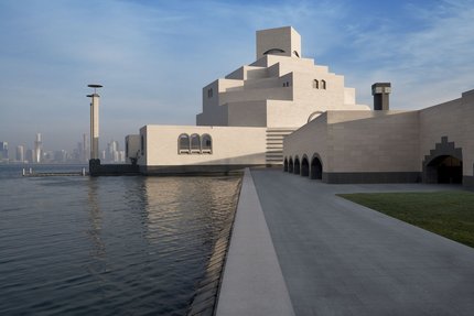 مسار إلى متحف الفن الإسلامي بجانب الماء وتظهر مدينة الدوحة في الخلفية