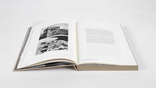 Open double page book displaying monochromatic photographs with supporting informational text