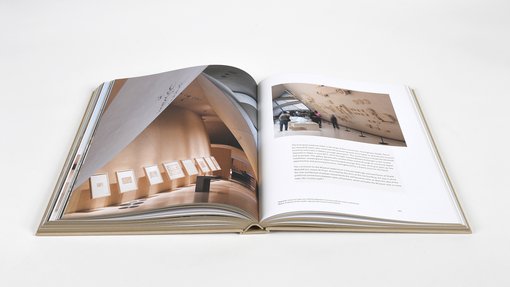 Open double page book displaying an interior section of the National Museum of Qatar with supporting informational text