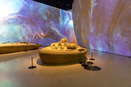 Interior of a gallery space at the National Museum of Qatar with galaxy projection on the walls