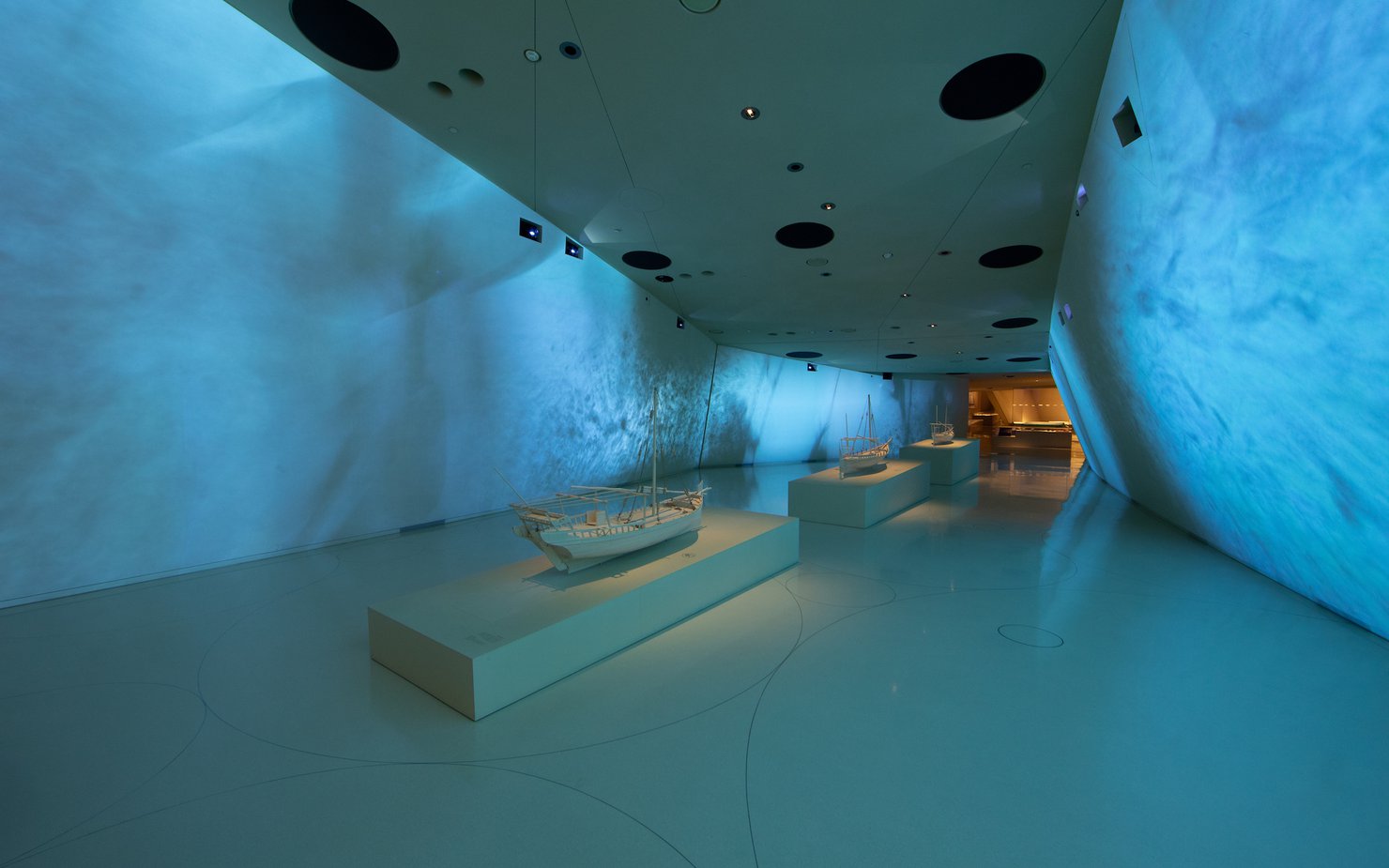 Interior of a gallery space at the National Museum of Qatar showcasing traditional dhow boats
