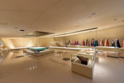 صالة عرض في متحف قطر الوطني تحتوي على الأزياء التقليدية، والسجاد، والمجوهرات