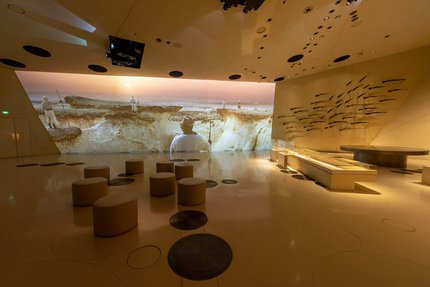 صالة عرض في متحف قطر الوطني مع شاشة عرض كبيرة