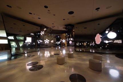 Interior of a gallery space at the National Museum of Qatar with several digital projections on the walls