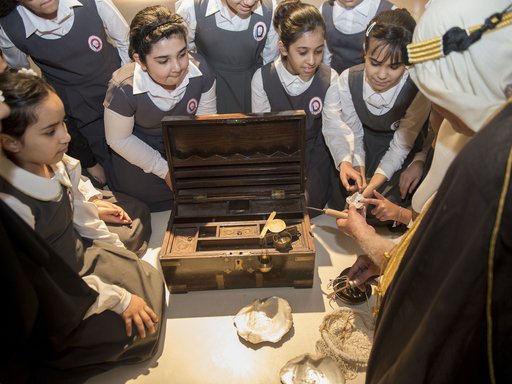 Students observing a man handling an old pearl diving kit