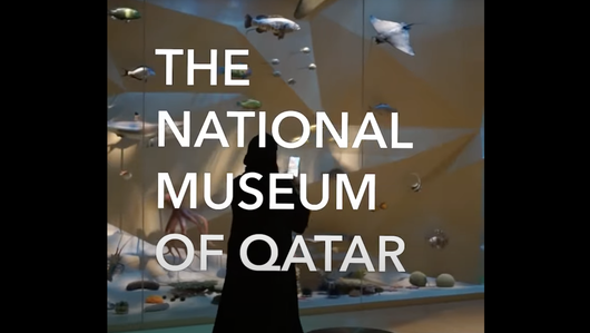 Woman looking at objects inside the National Museum of Qatar's gallery