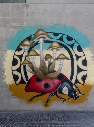 A mural depicting a ladybug with mushrooms coming out of its back.