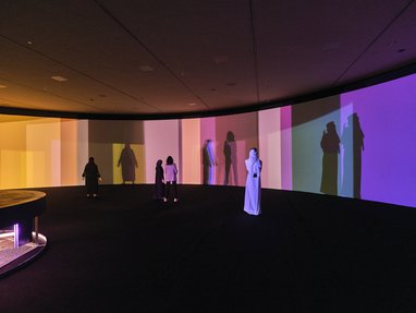 A room with rainbow coloured colour blocking effects surrounding the walls of the gallery space.