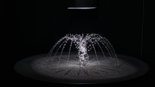 A small water fountain in a dark room.