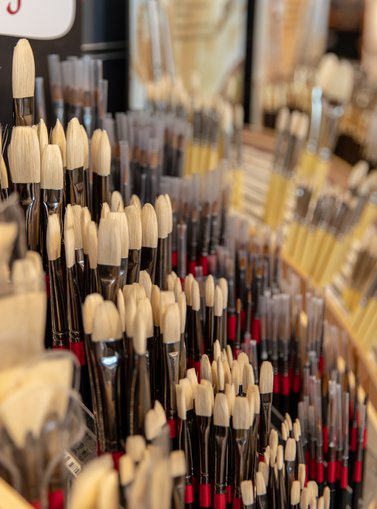 A shop display showing different types and sizes of artist paint brushes