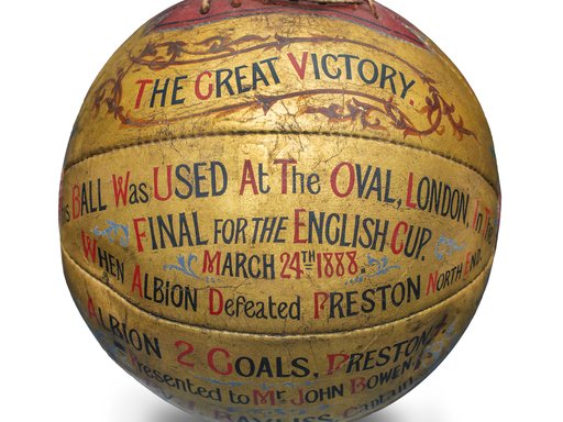 A golden coloured football with text that reads 'This ball was used at the Oval, London, in the final for the English Cup, March 24th 1888.