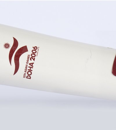 A horizontal white torch with a burgundy leather strap and the logo of Doha 2006 Asian Games