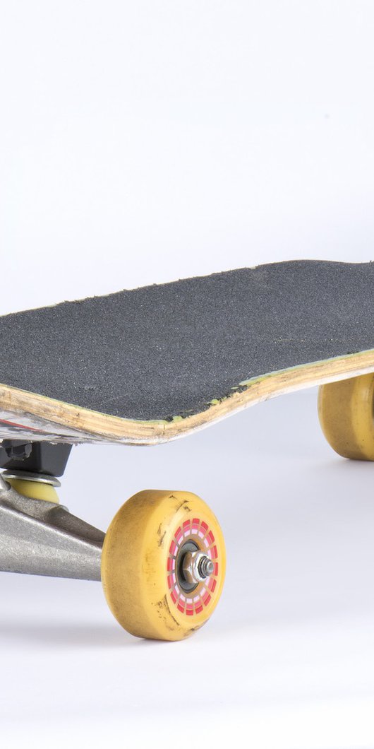 A skateboard with yellow wheels, red underbelly and dark grey grip.