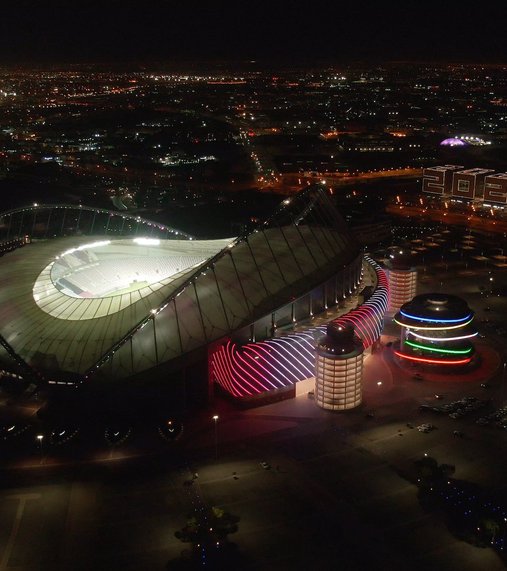 A night time image of QOSM flanked by Khalifa International Stadium