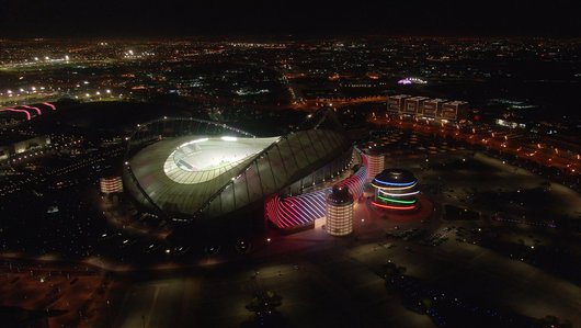 A night time image of QOSM flanked by Khalifa International Stadium