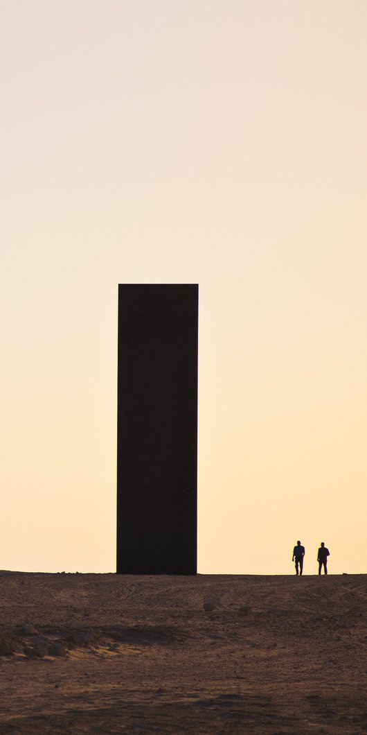 A wide shot of Richard Serra's East-West-West-East at sunset