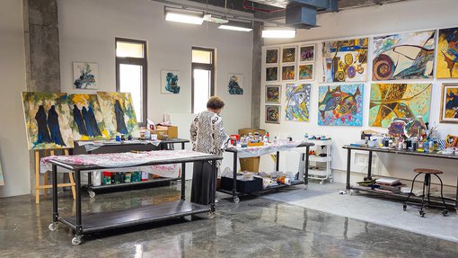 Ruwad Artist Wafika Sultan Al-Essa working in the corner of her studio at the Fire Station.