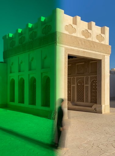 A contemporary image of a woman in black walking in front of a Qatari historic building.