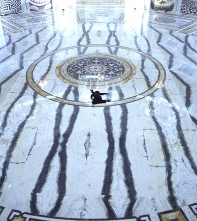 Woman shown splayed against black and white marble floor.