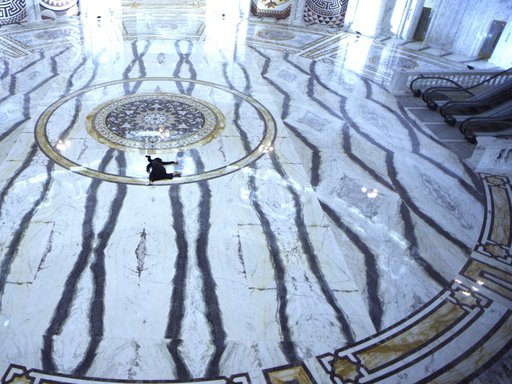 Woman shown splayed against black and white marble floor.