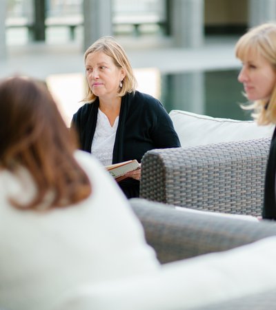 A medium shot of three women looking ahead at a meeting