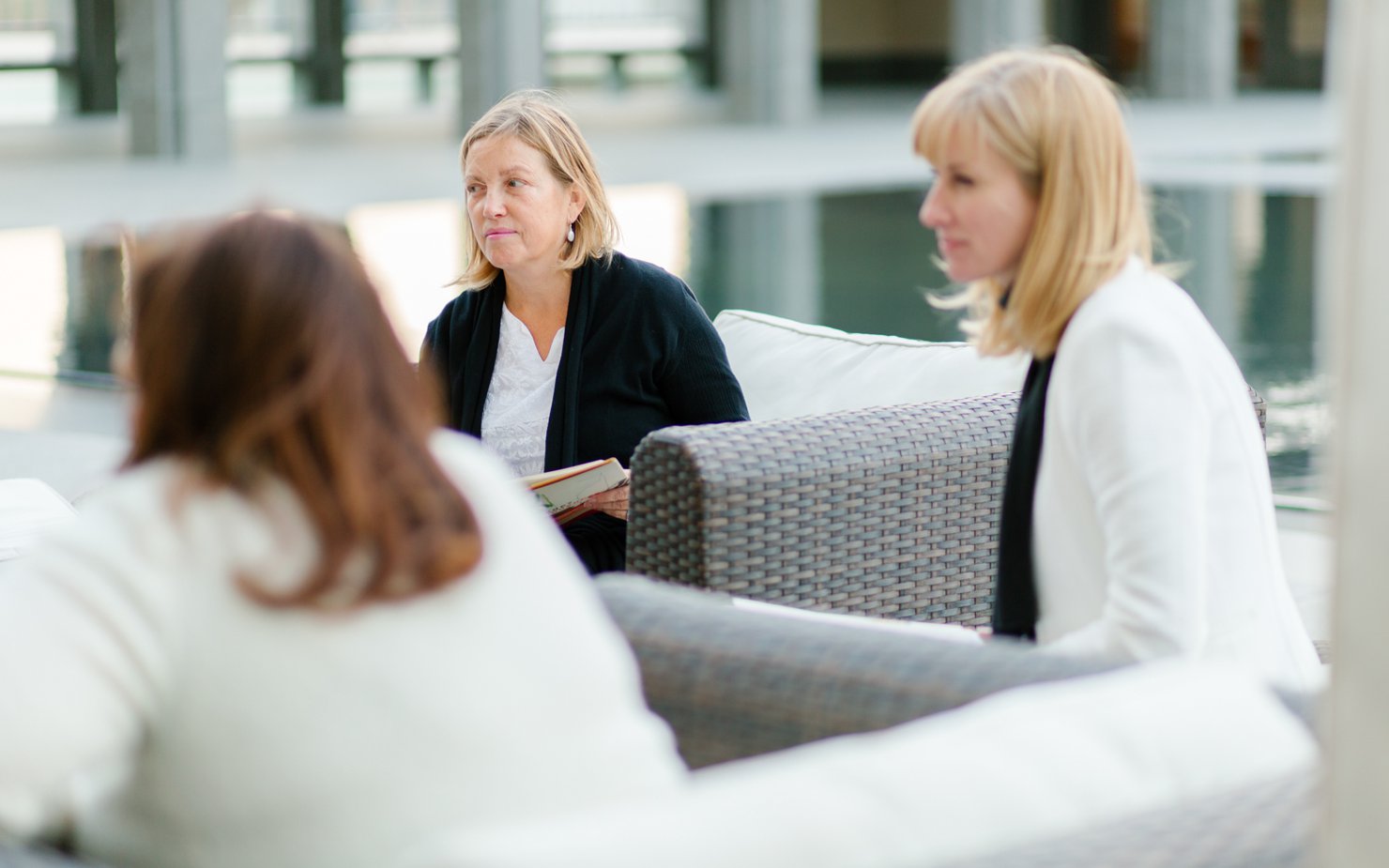 A medium shot of three women looking ahead at a meeting
