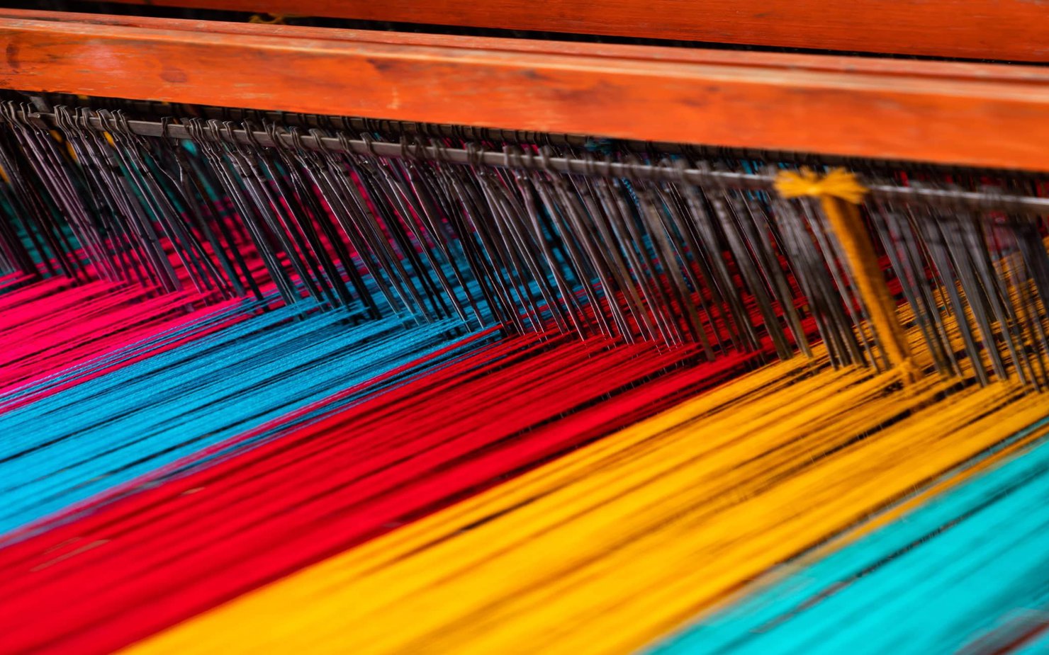 A textile weaving machine weaving multi-coloured threads