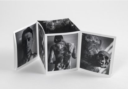 A foldout zine publication showing black and white images of a man and a skull..